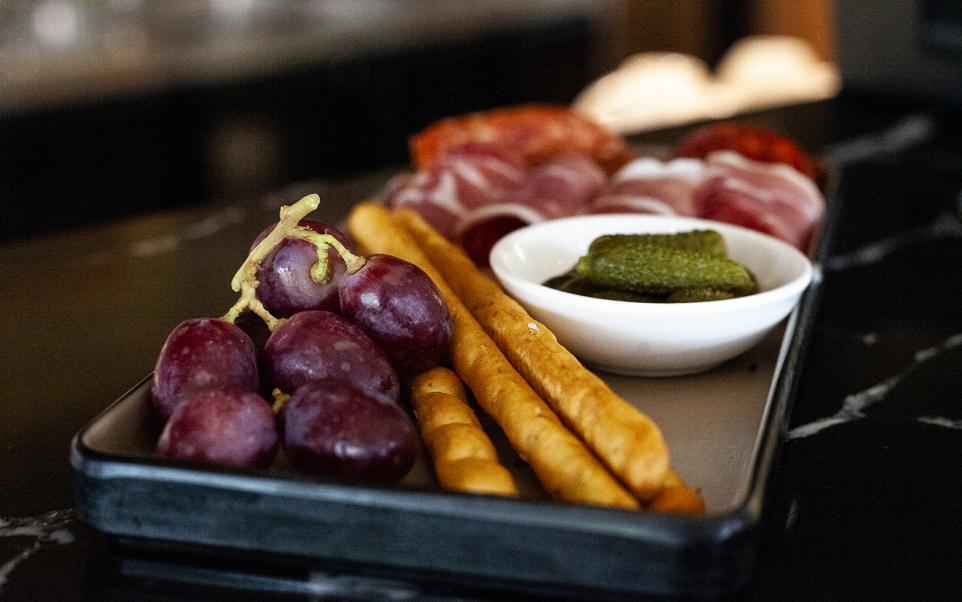 Platter with salami, grapes and breadsticks