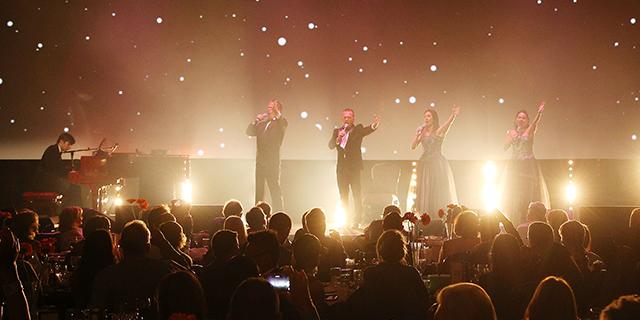 4 singers on stage in front of a crowd