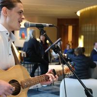 A singer on guitar performs during Fab Friday 