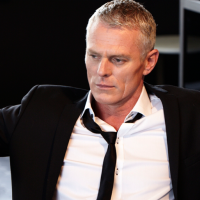 Michael Cormick sits on a chair looking quite nifty. 