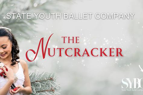 A young ballerina colds a traditional nutcracker toy.