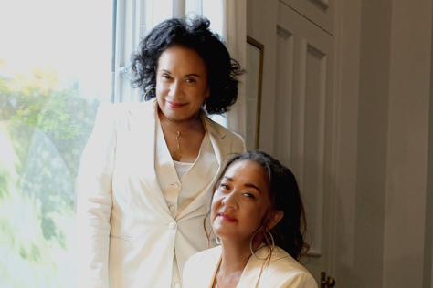 Vika and Linda Bull pose for the camera, both in matching cream suits