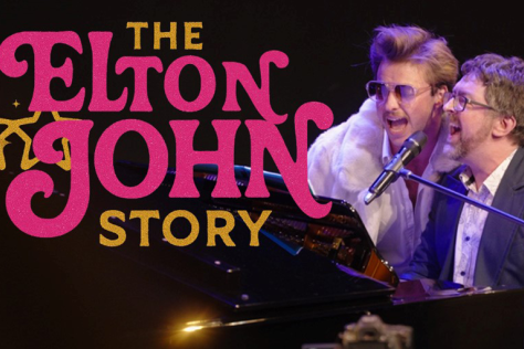 Two men sing at a piano
