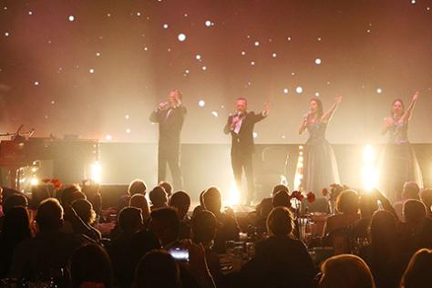 4 singers on stage in front of a crowd