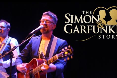 The Simon & Garfunkel Story logo with 2 men with guitars singing at microphones.