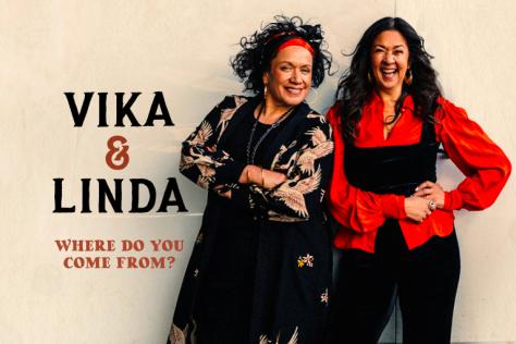 Vika and Linda smile in front of a wall