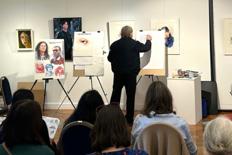 Artist doing painting demonstration in gallery for audience