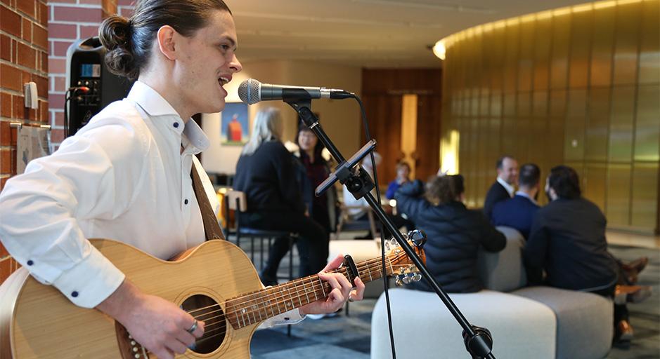 A singer on guitar performs during Fab Friday 