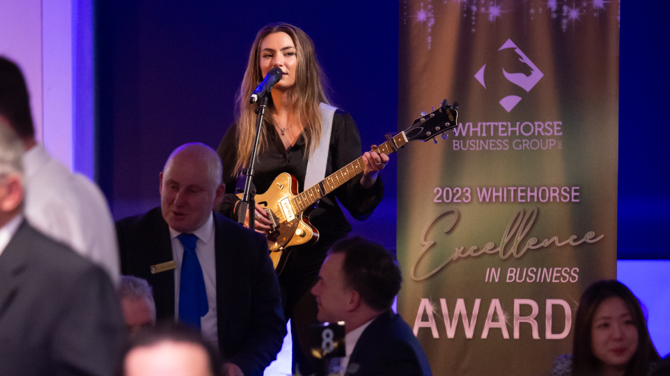 A woman playing guitar at a conference