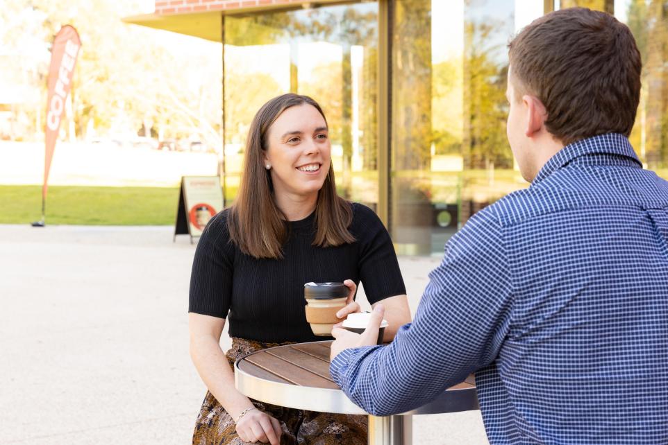 man and woman outdoors drinking coffe 